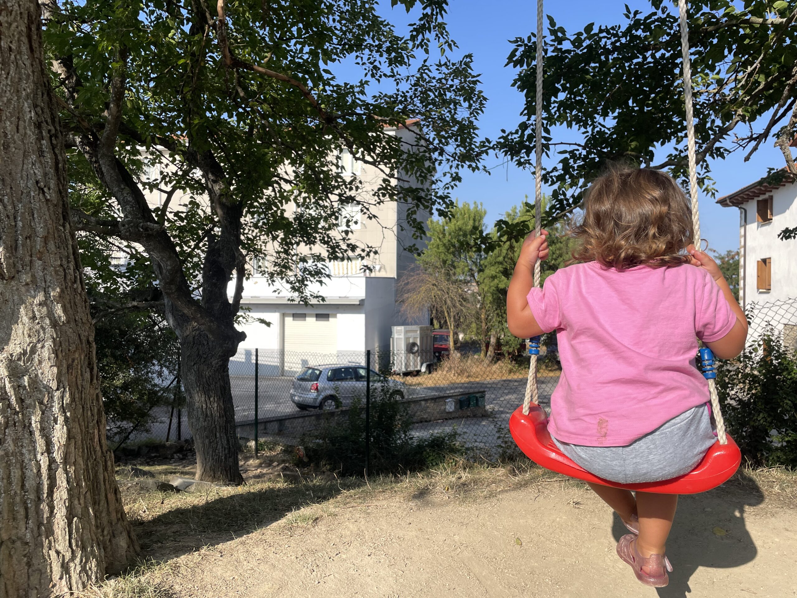 Niña columpiándose en un campamento de la Granja Naturalia en Esquiroz
