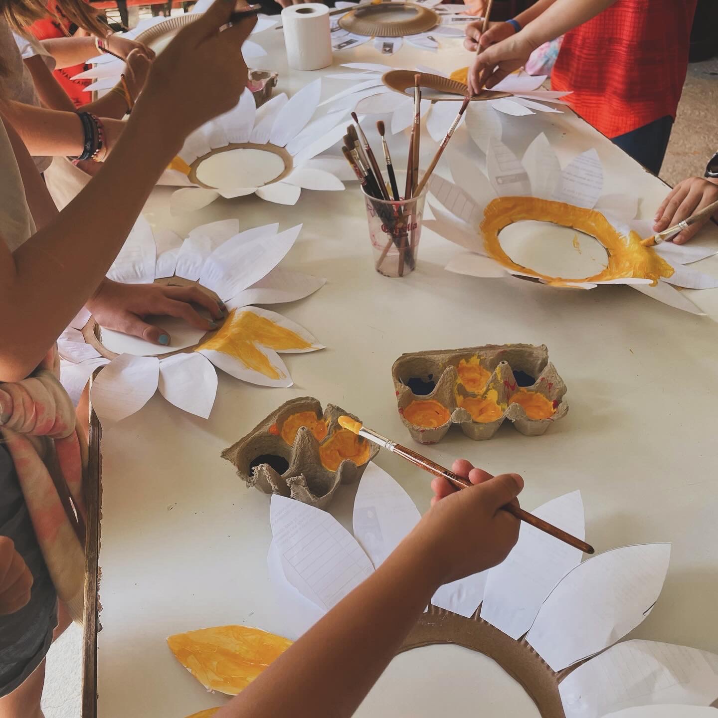niños pintando flores de papel en un taller de manualidades durante las actividades extraescolares en la granja escuela Naturalia de Esquíroz